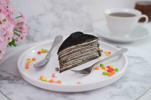 Piece of homemade chocolate crepes cake on a white plate photo