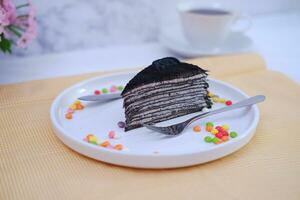 Piece of homemade chocolate crepes cake on a white plate photo