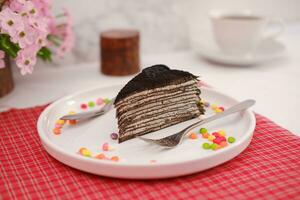 Piece of homemade chocolate crepes cake on a white plate photo