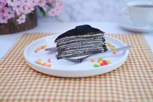 Piece of homemade chocolate crepes cake on a white plate photo