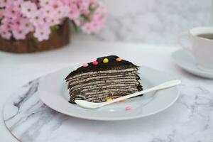 Piece of homemade chocolate crepes cake on a white plate photo