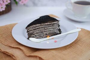 Piece of homemade chocolate crepes cake on a white plate photo