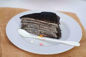 Piece of homemade chocolate crepes cake on a white plate photo