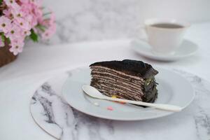 Piece of homemade chocolate crepes cake on a white plate photo