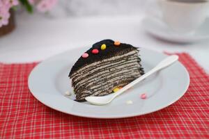 Piece of homemade chocolate crepes cake on a white plate photo
