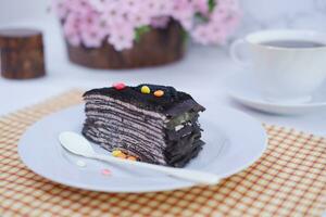 Piece of homemade chocolate crepes cake on a white plate photo