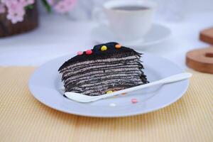 Piece of homemade chocolate crepes cake on a white plate photo