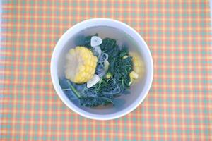 Sayur Bening Daun kelor jagung or Moringa Oleifera clear soup with sweet corn served in bowl photo