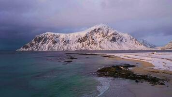 skagsanden spiaggia, norvegese mare e montagne nel inverno. tempestoso cielo. lofoten isole, Norvegia. aereo Visualizza. fuco mosche indietro video