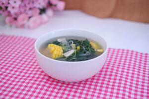 Sayur Bening Daun kelor jagung or Moringa Oleifera clear soup with sweet corn served in bowl photo