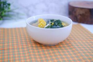 Sayur Bening Daun kelor jagung or Moringa Oleifera clear soup with sweet corn served in bowl photo