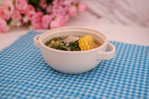 Sayur Bening Daun kelor jagung or Moringa Oleifera clear soup with sweet corn served in bowl photo