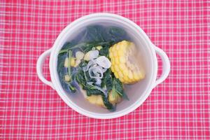 Sayur Bening Daun kelor jagung or Moringa Oleifera clear soup with sweet corn served in bowl photo