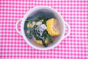 Sayur Bening Daun kelor jagung or Moringa Oleifera clear soup with sweet corn served in bowl photo