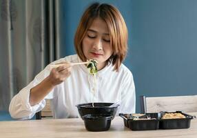 woman sitting at chair enjoy eating delicious set box food having takeaway at home relaxing resting and happy lifestyle concepts photo