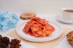 Keripik singkong balado or balado cassava chips on a serving plate, it tastes spicy, sweet and crunchy photo