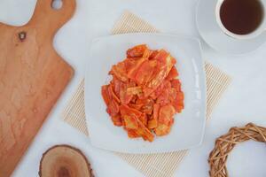 Keripik singkong balado or balado cassava chips on a serving plate, it tastes spicy, sweet and crunchy photo