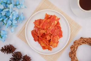 Keripik singkong balado or balado cassava chips on a serving plate, it tastes spicy, sweet and crunchy photo