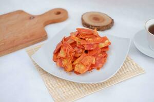 Keripik singkong balado or balado cassava chips on a serving plate, it tastes spicy, sweet and crunchy photo