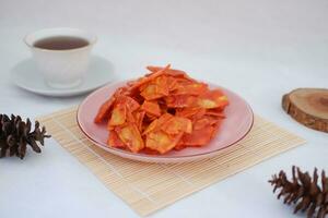 Keripik singkong balado or balado cassava chips on a serving plate, it tastes spicy, sweet and crunchy photo
