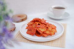 Keripik singkong balado or balado cassava chips on a serving plate, it tastes spicy, sweet and crunchy photo