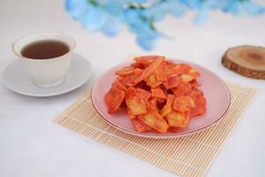 Keripik singkong balado or balado cassava chips on a serving plate, it tastes spicy, sweet and crunchy photo