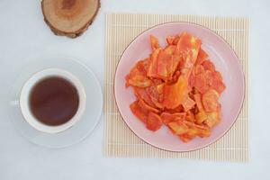 Keripik singkong balado or balado cassava chips on a serving plate, it tastes spicy, sweet and crunchy photo