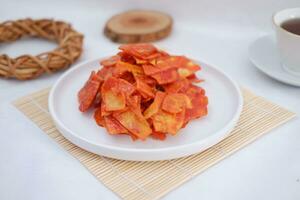Keripik singkong balado or balado cassava chips on a serving plate, it tastes spicy, sweet and crunchy photo