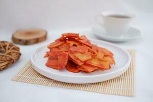 Keripik singkong balado or balado cassava chips on a serving plate, it tastes spicy, sweet and crunchy photo