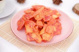 Keripik singkong balado or balado cassava chips on a serving plate, it tastes spicy, sweet and crunchy photo