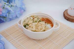 Bubur ayam or rice porridge with shredded chicken photo