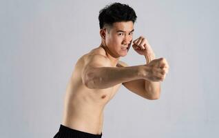 imagen de asiático masculino atleta con bueno físico en blanco antecedentes foto