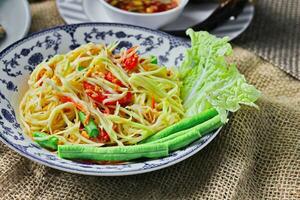 Delicious Thai food on the table in a restaurant in Thailand, papaya salad, larb, waterfall, sticky rice. photo