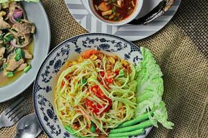 Delicious Thai food on the table in a restaurant in Thailand, papaya salad, larb, waterfall, sticky rice. top view, layout, flatlay photo