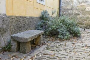 Image of a stone bench in front of an old building in a historic kraot village photo