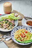Delicious Thai food on the table in a restaurant in Thailand, papaya salad, larb, waterfall, sticky rice. photo