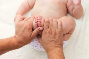 masseur doing massage for foot little baby photo