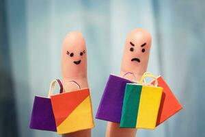 Finger art of couple with shopping bags. Man is unhappy photo