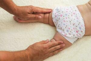 masseur doing massage for foot little baby photo