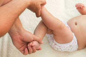 masseur doing massage for foot little baby photo