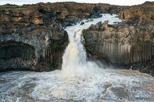 Powerful Aldeyjarfoss waterfall flowing from ancient Badardalshraun lava field and basalt column in summer at Iceland photo