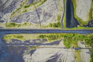 Asphalt road cut through mossy remote wilderness in rural scene photo