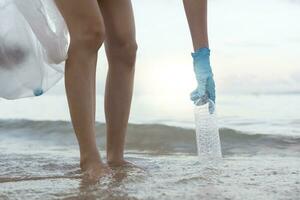 Save ocean. Volunteer pick up trash garbage at the beach and plastic bottles are difficult decompose prevent harm aquatic life. Earth, Environment, Greening planet, reduce global warming, Save world photo