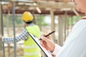 inspector or engineer is inspecting construction and quality assurance new house using a checklist. Engineers or architects or contactor work to build the house before handing it over to the homeowner photo