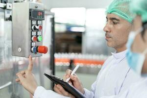 quality supervisor or food or beverages technician change parameter and condition control food or beverages before send product to the customer. Production leader recheck machine and productivity. photo