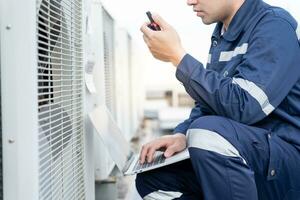 maintenance engineer work on the roof of factory. contractor inspect compressor system and plans installation of air condition systems in construction. technology, walky talky, maintenance photo