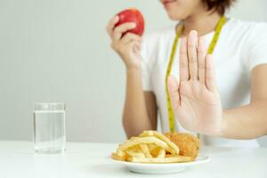 Delgado hembra cuerpo confundir francés papas fritas y frito pollo. mujer en restaurante logra peso pérdida objetivo para sano vida, loco acerca de delgadez, Delgado cintura, nutricionista. dieta, cuerpo forma. foto