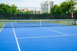 todo azul tenis corte, sintético caucho césped foto