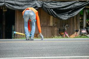 Worker wearing uniform is striping with measuring on the road photo