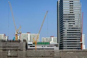 Construction site building with yellow crane and scaffolding photo